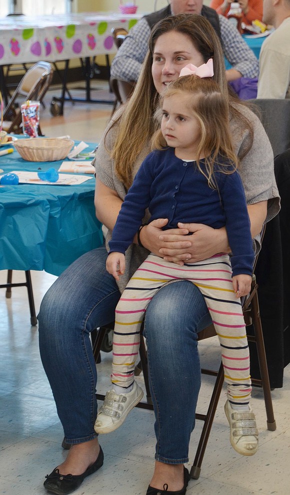 Rachel Allmashy and her 3-year-old daughter Victoria, Rye Brook residents, are completely absorbed by Macaroni the Clown’s performance. 