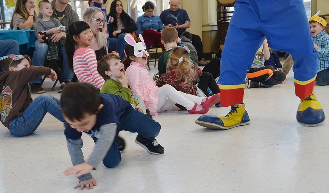 Kids scream and scatter as Macaroni the Clown waves around a giant snake stuffed animal and tries to drop it on them.       