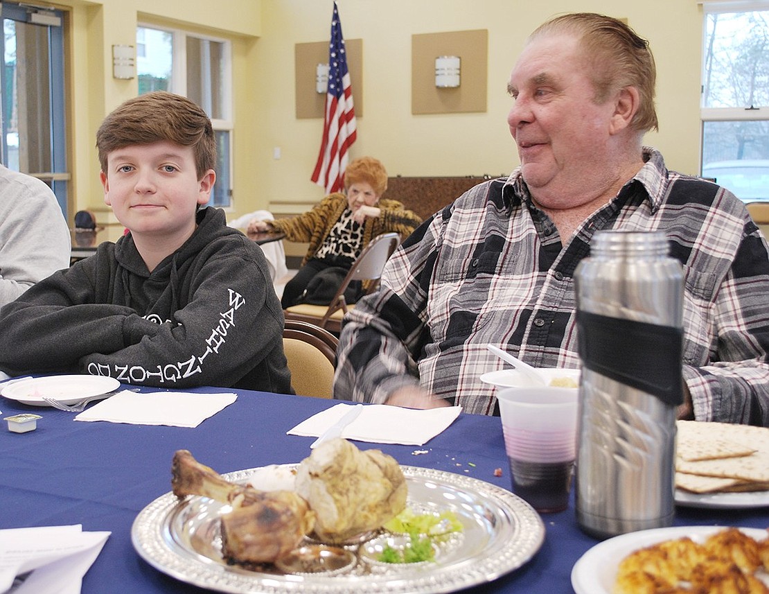 Hillcrest Avenue resident Bill Barber and 14-year-old Port Chester Middle School student Noah Rotfeld are seated at the head of the table, right in front of the Seder plate with foods symbolizing the story of Passover.