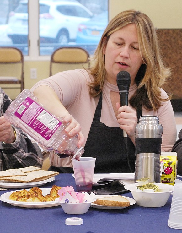 Using grape juice to represent wine, Rye Brook Seniors Coordinator Elizabeth Rotfeld pours the traditional cup for Elijah. 