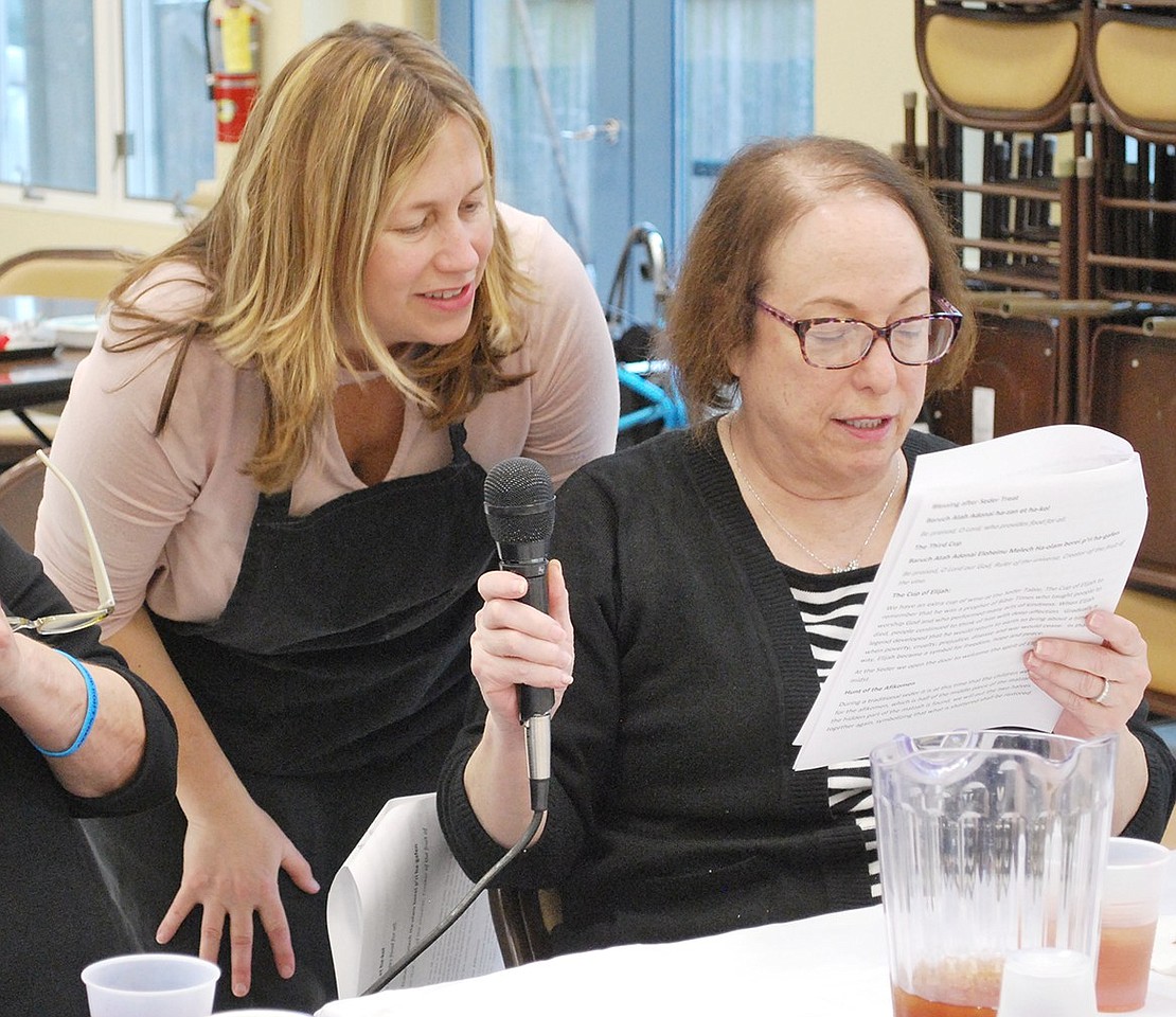 Concluding the Passover feast, Berkley Drive resident Lynn Freedman (right) and Rye Brook Seniors Coordinator Elizabeth Rotfeld sing “Dayenu” into the microphone.   