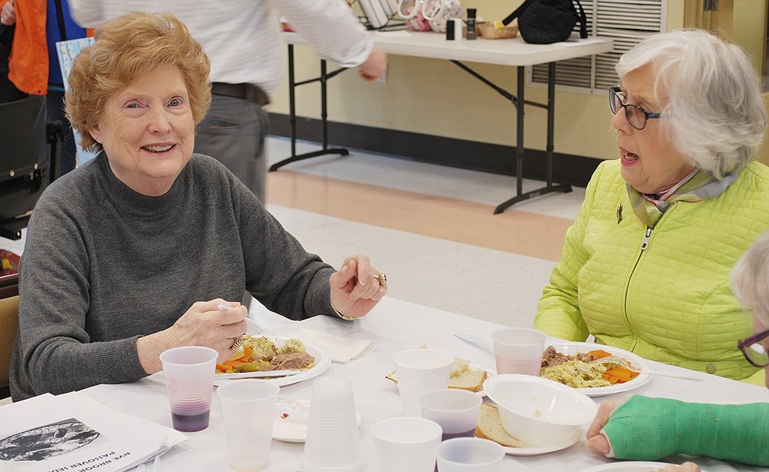 Woodland Avenue resident Barbara Nardi and Greenway Circle resident Joan Gourin catch up with each other over a hot plate of brisket. 