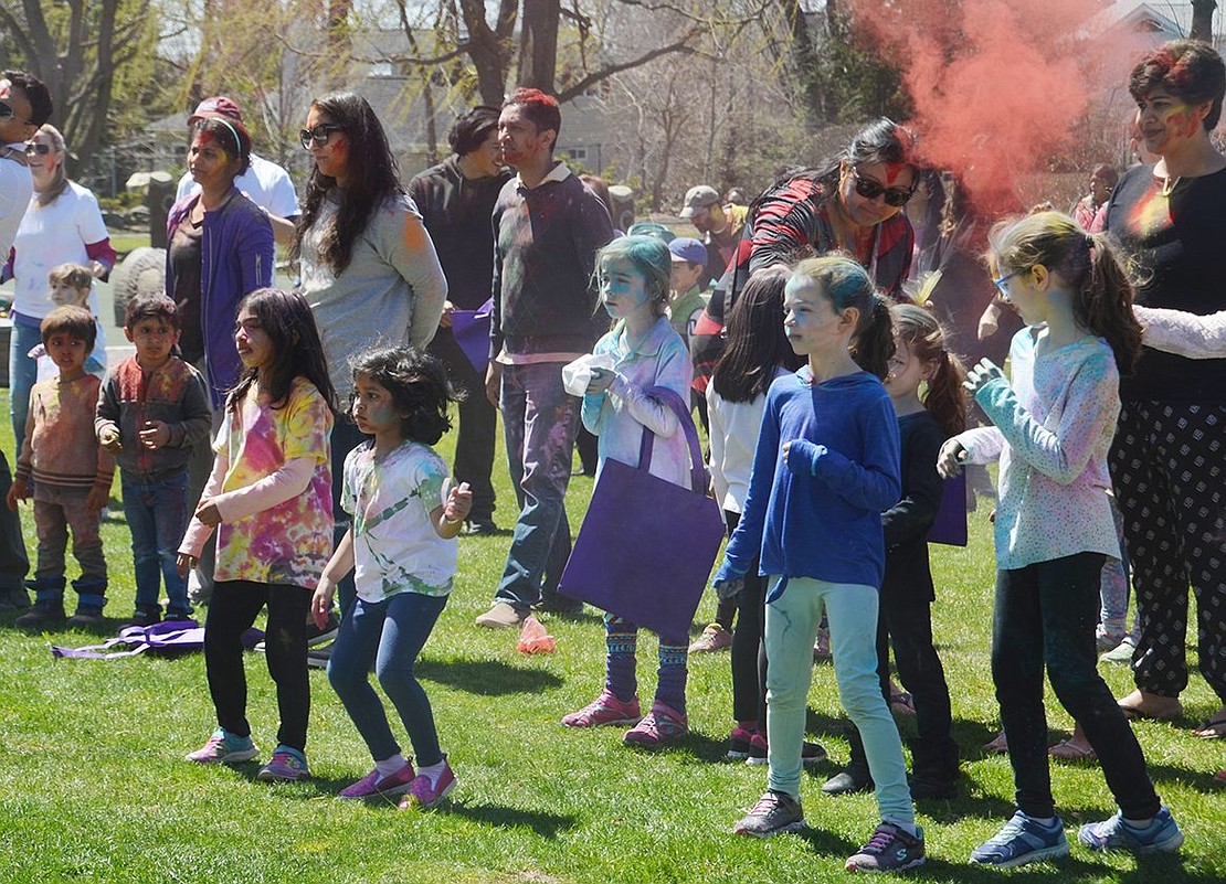 Children and parents covered head to toe with different vibrant colors gather to watch traditional Indian performances and dance along to music during Colorblast at Crawford Park on Sunday, Apr. 22. 