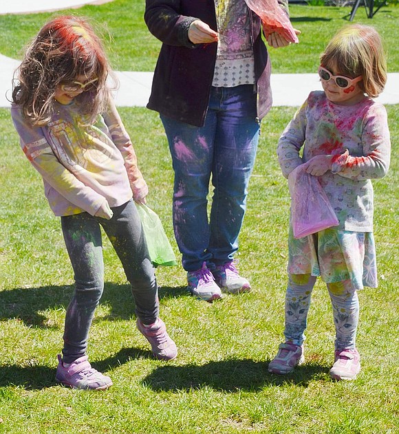 After whipping some pink color powder at Sleepy Hollow Road resident Casey Craighead, 6, 4-year-old Sarah Craighead reaches in her bag for more. 