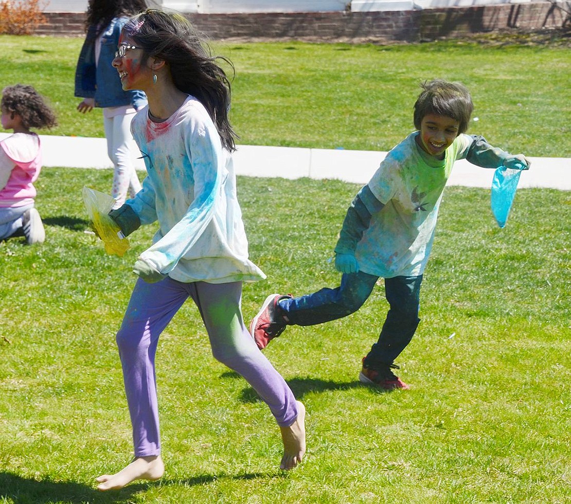 With a bag of blue powder in hand, 5-year-old Greenwich, Conn. resident Armaah Khwaja giggles while he chases his 8-year-old sister Amaya around Crawford Park. 