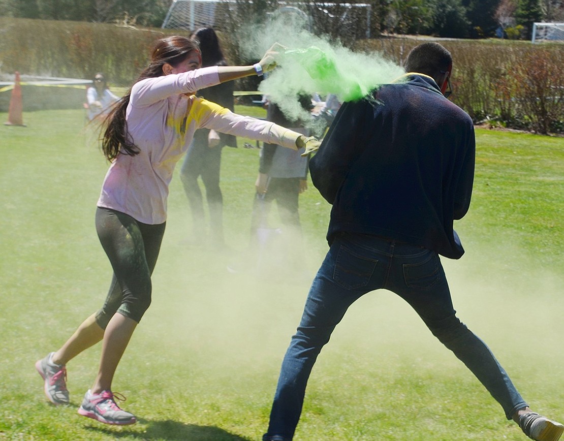 Color battles aren’t just for kids! Visiting performer from North Carolina Shelley Jain drenches her Boston resident cousin Shrenik Jian with lime green powder. 