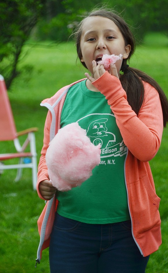 Craving a Sunday afternoon sweet treat, Edison Elementary School fifth-grader Vanessa Lunarejo enjoys her stick of pink fluffy cotton candy. 