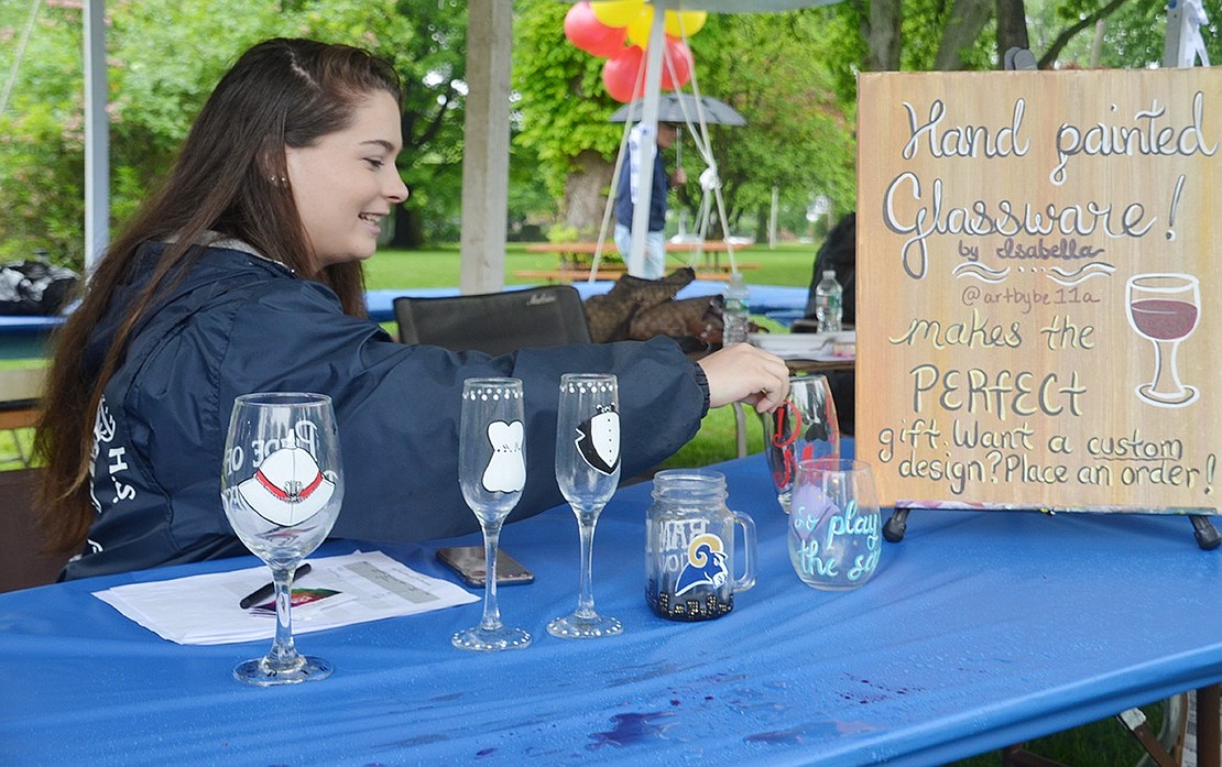 Sylvan Road resident Isabella Roca, 20, sets up her Port Chester-themed, hand-painted glasses to sell during the festival. 