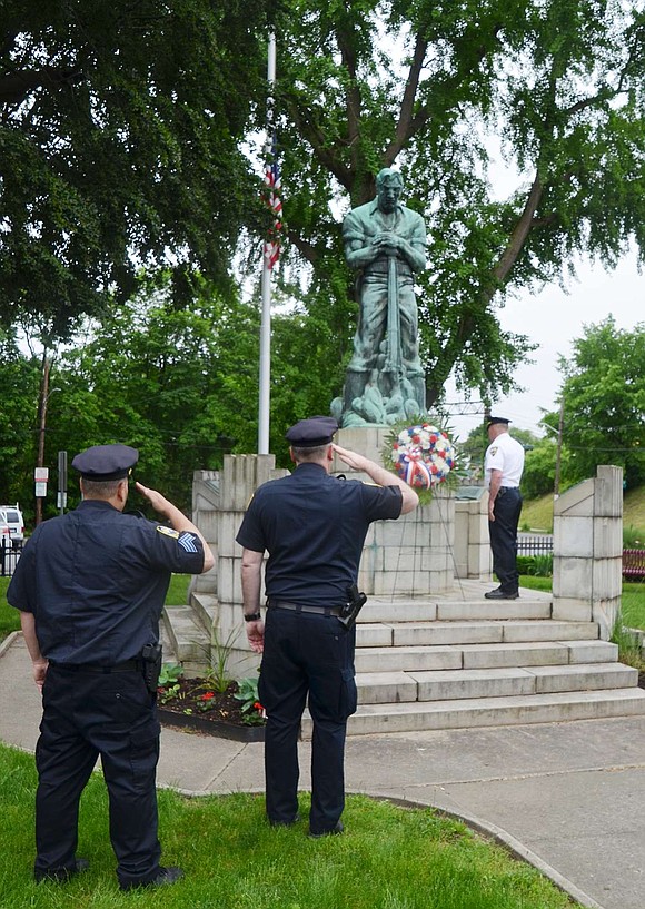 Port Chester Police Sgt. Michael Martello, Lt. Charles Nielsen (foreground) and Chief Richard Conway (background) salute after placing the memorial wreath on the Spanish-American War memorial at Summerfield Park on Memorial Day, May 28.