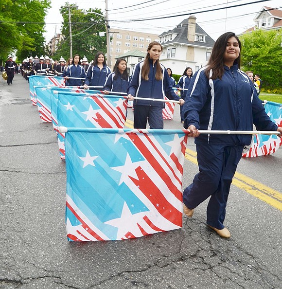 Port Chester High School Band Color Guard members march down Westchester Avenue in the parade following ceremonies at all the war memorials in Port Chester and Rye Brook Monday morning.