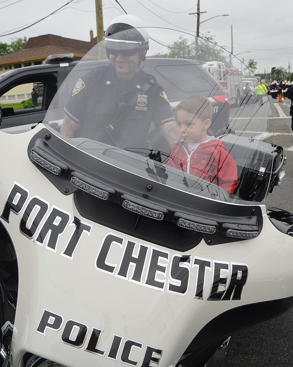 Luke Vizzo, 3, of North Main Street tries out a police motorcycle with Port Chester Police Officer Sal Baldo before the parade gets underway. Luke wants to be a police officer when he grows up, said his mom.