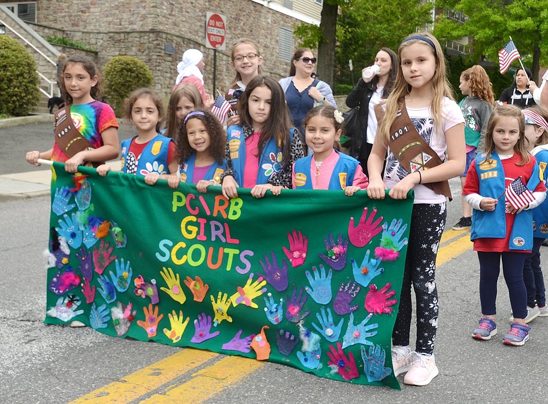 Girl Scouts from various troops march behind the Port Chester/Rye Brook Girl Scouts banner.