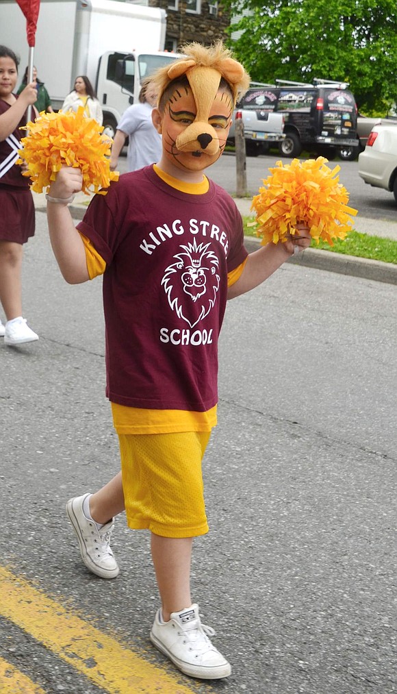 Second-grader Dominick Borcerra, decked out as a lion, the King Street School mascot, marches in the parade with his schoolmates. 