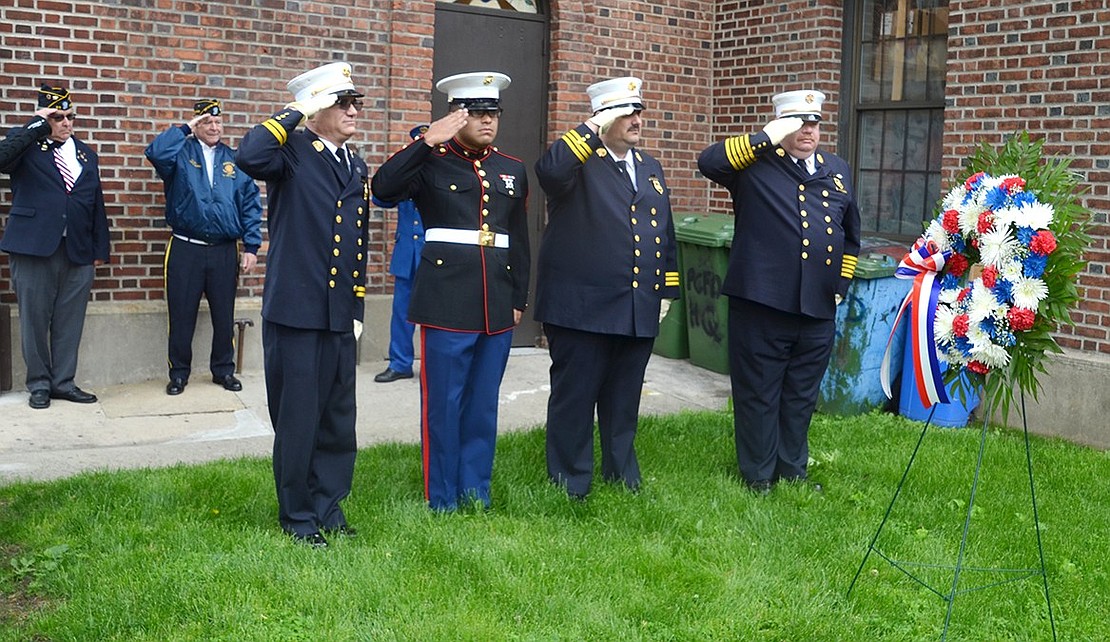 From left, Port Chester 2nd Assistant Fire Chief Herbert Bocchino, José Gonzalez of the U.S. Marine Corps, a member of Putnam Engine & Hose Company, 1st Assistant Chief Enrico Casterella and Chief Michael DeVittorio salute during a Memorial Day ceremony at the firefighters’ memorial adjacent to fire headquarters on Westchester Avenue.