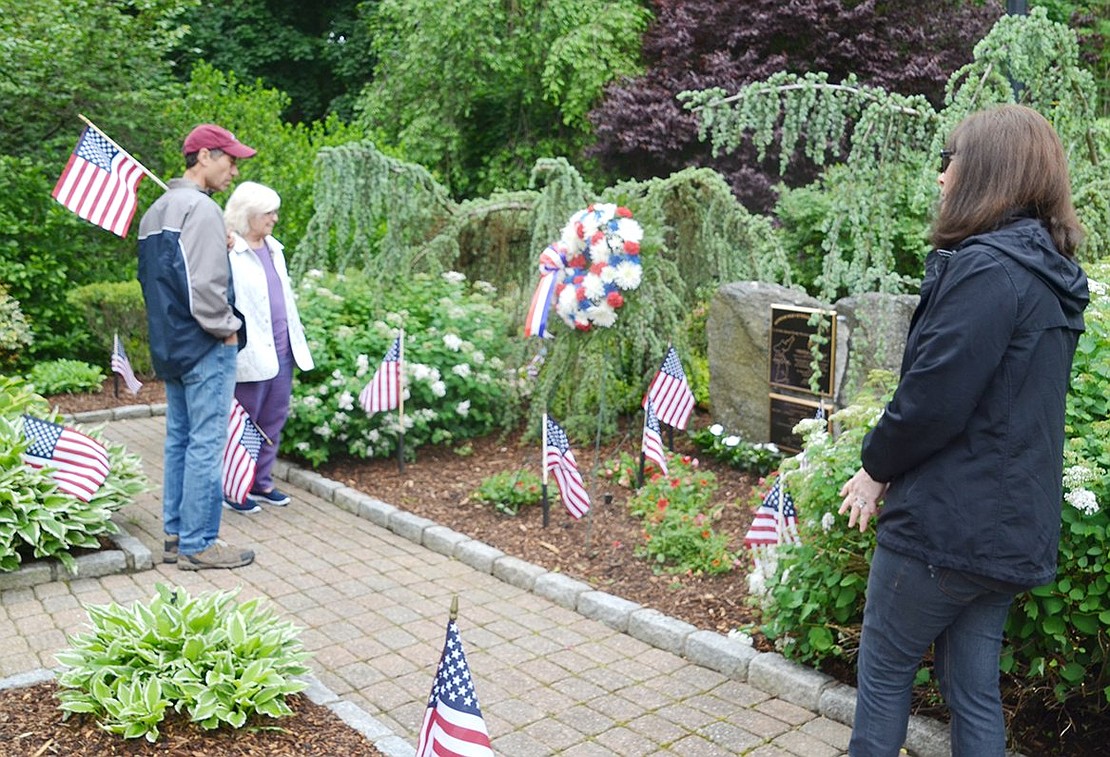 Barry Albalah of Rye Brook speaks with Patricia DeLuca of Greenwich, whose brother’s name is on the memorial plaque at the Korean War memorial at Crawford Park before the Memorial Day ceremony there. Anthony Joseph Cotroneo died at age 19 on Nov. 1, 1951. “I’ll never forget it,” said DeLuca. Leslee Albalah, at right, admires the well-landscaped memorial.