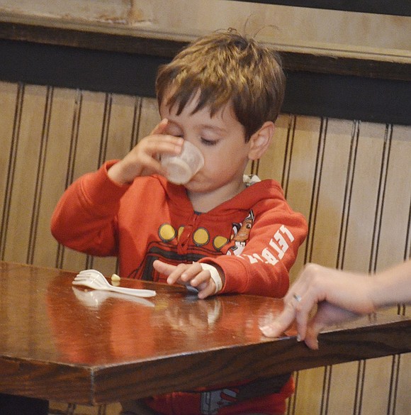 Determined to get every last bit of his shepherd’s pie, 3-year-old Anthony Scutero of Rye Brook licks his plastic cup clean at McShane’s Public House at 123 N. Main St.   