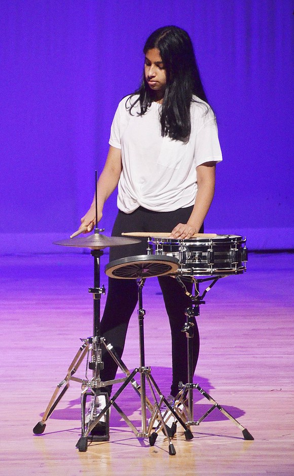 Blind Brook eighth-grader Archana Kumaran gracefully taps a cymbal to accompany “Skinny Love.” In their digital media class, Kumaran, Vivian Carvalho and Tiffany Chao created a music video for Bon Iver’s original piece and then performed their own rendition with vocals (Carvalho), piano (Chao) and drums for an audience in the auditorium. 