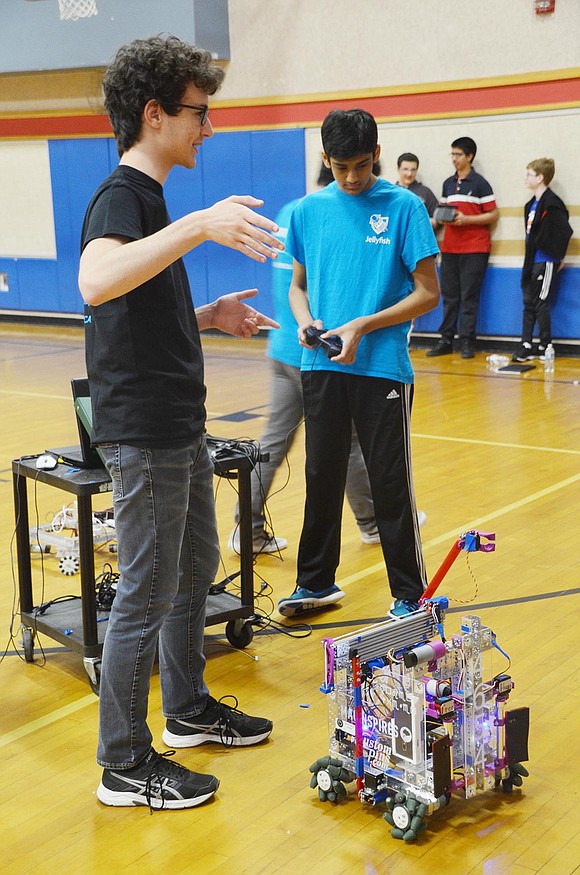 Promoting the high school robotics club to middle schoolers, junior Matias Goldfeld describes what the Jellyfish team does while sophomore Arnav Mohapatra demonstrates their robot’s capabilities. 