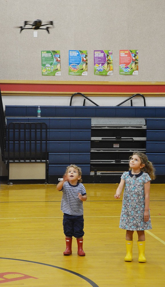 While the unpictured Blind Brook eighth-grader Raghav Joshi flies a drone across the gymnasium, Stella, 5, and Adrian Soto, 2, chase it around in awe. The Greenwich residents are visiting Creaticon to support their father, Andre, who established the exhibition three years ago to showcase student imagination and creativity.