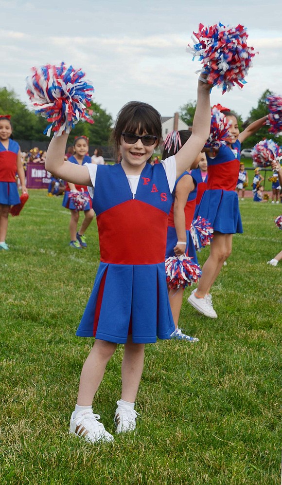 Looking cool with her shades, Park Avenue second-grader Ryann Onofrio-Franceschini waves her pom-poms around to warm up before the performance. 