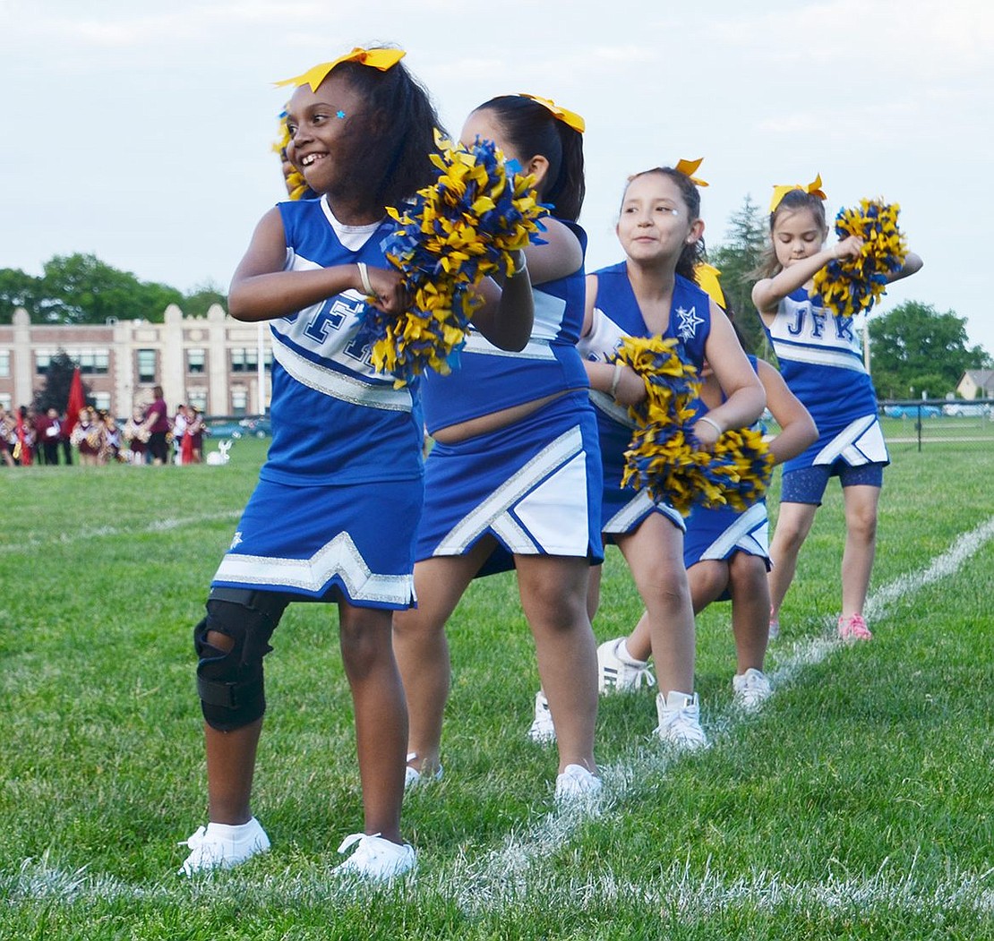 Third-grader Makayla Yan leads the line of John F. Kennedy Elementary School cheerleaders dancing and shuffling their pom-poms around. 