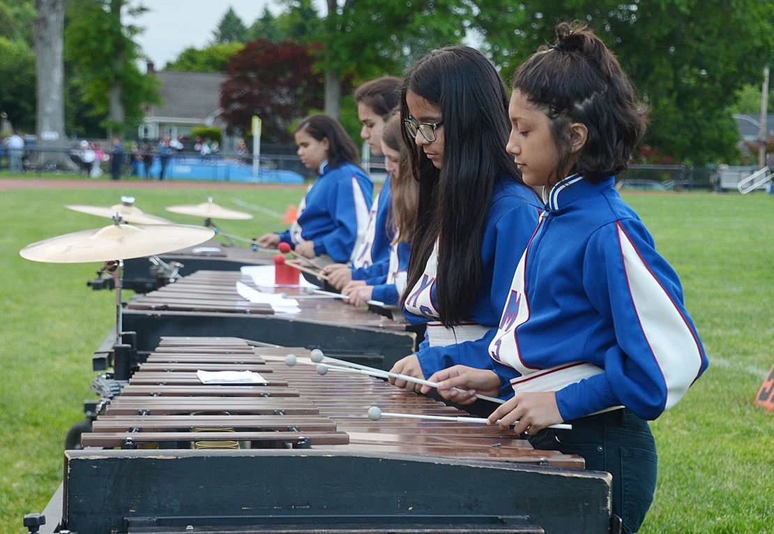 Establishing rhythm and tempo in the pit, Port Chester Middle School seventh-graders Madeline Saunders (front) and Cherilyn Garcia hammer a xylophone together. 