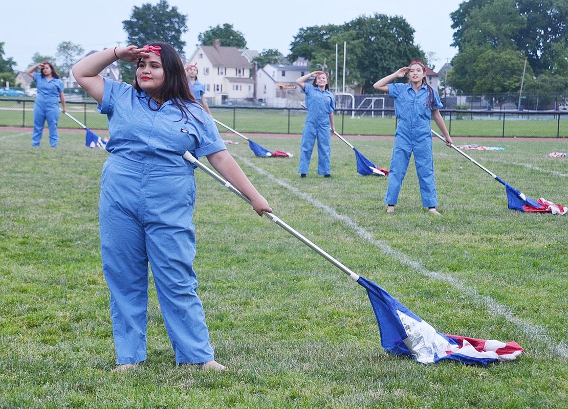 At the end of the Port Chester High School Marching Band’s World War II era-themed field show, sophomore Stephanie Villanueva poses in the Rosie the Riveter Salute with other color guard members.