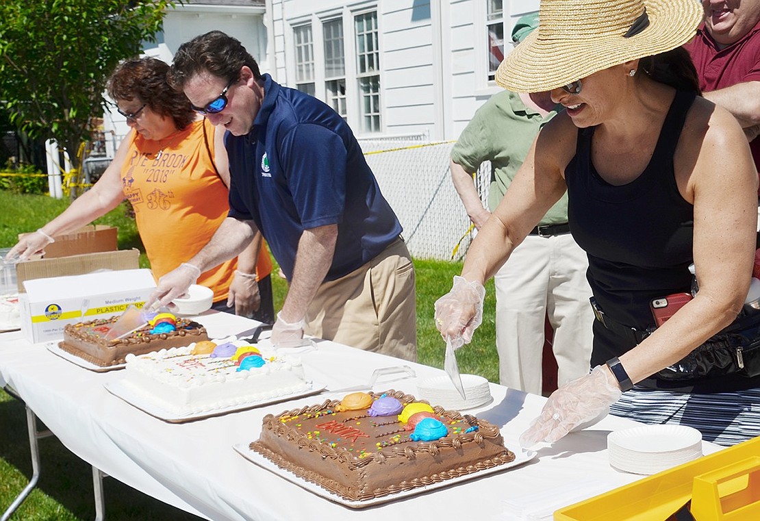 After the community gathered to sing “Happy Birthday” to Rye Brook, Village Trustee Susan Epstein (right), Trustee Jason Klein and Rye Brook Recreation Leader Janice Kunicki cut the cakes to serve to attendees at the Village of Rye Brook’s 36th birthday party at Crawford Park on Saturday, June 16.