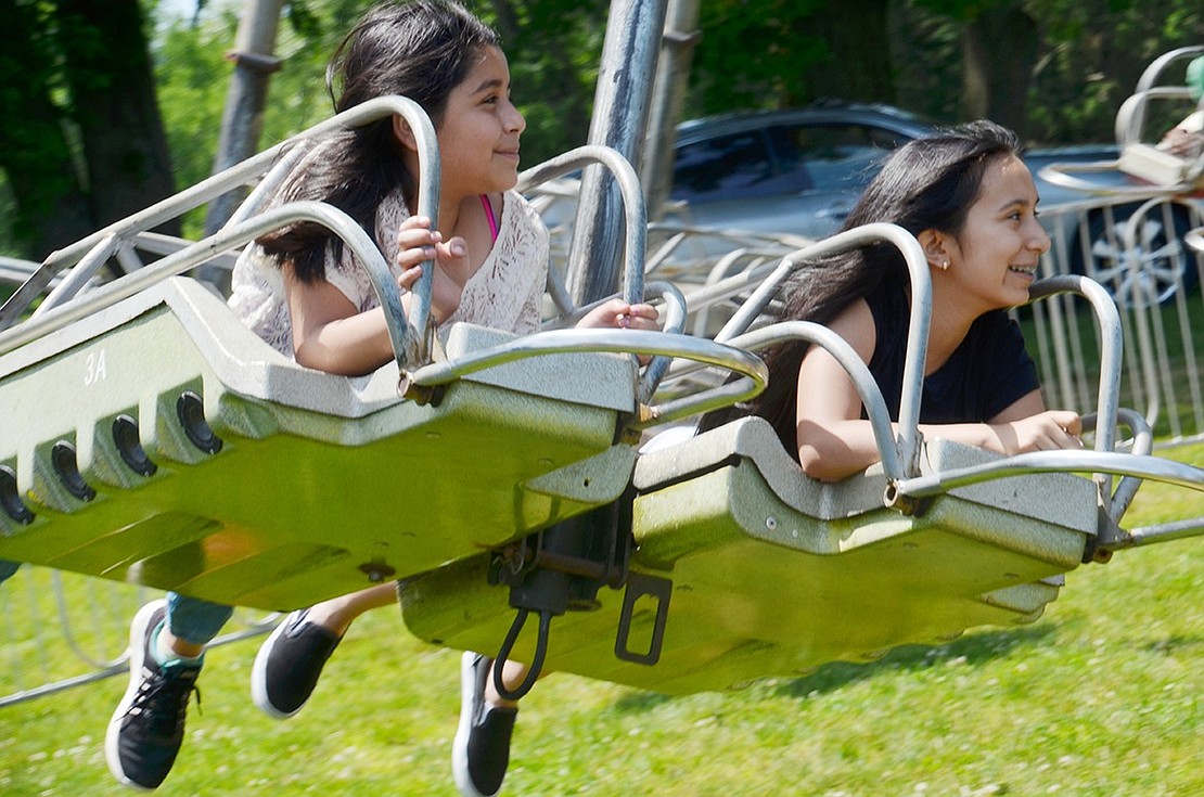 Port Chester Middle School sixth-grader Bramdely Perez (left) and seventh-grader Marie Bravo have a pleasant time riding the Space Sled.  