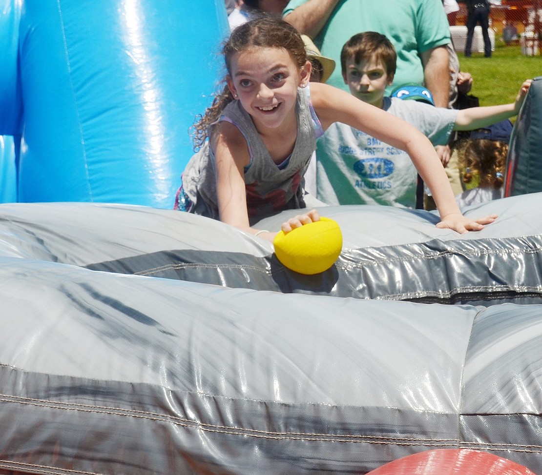 After making a dive for a ball in the Hungry Hungry Hippos inflatable life-size game, Ridge Street Elementary School third-grader Marissa Hamlet comes out of the center pot successful. 