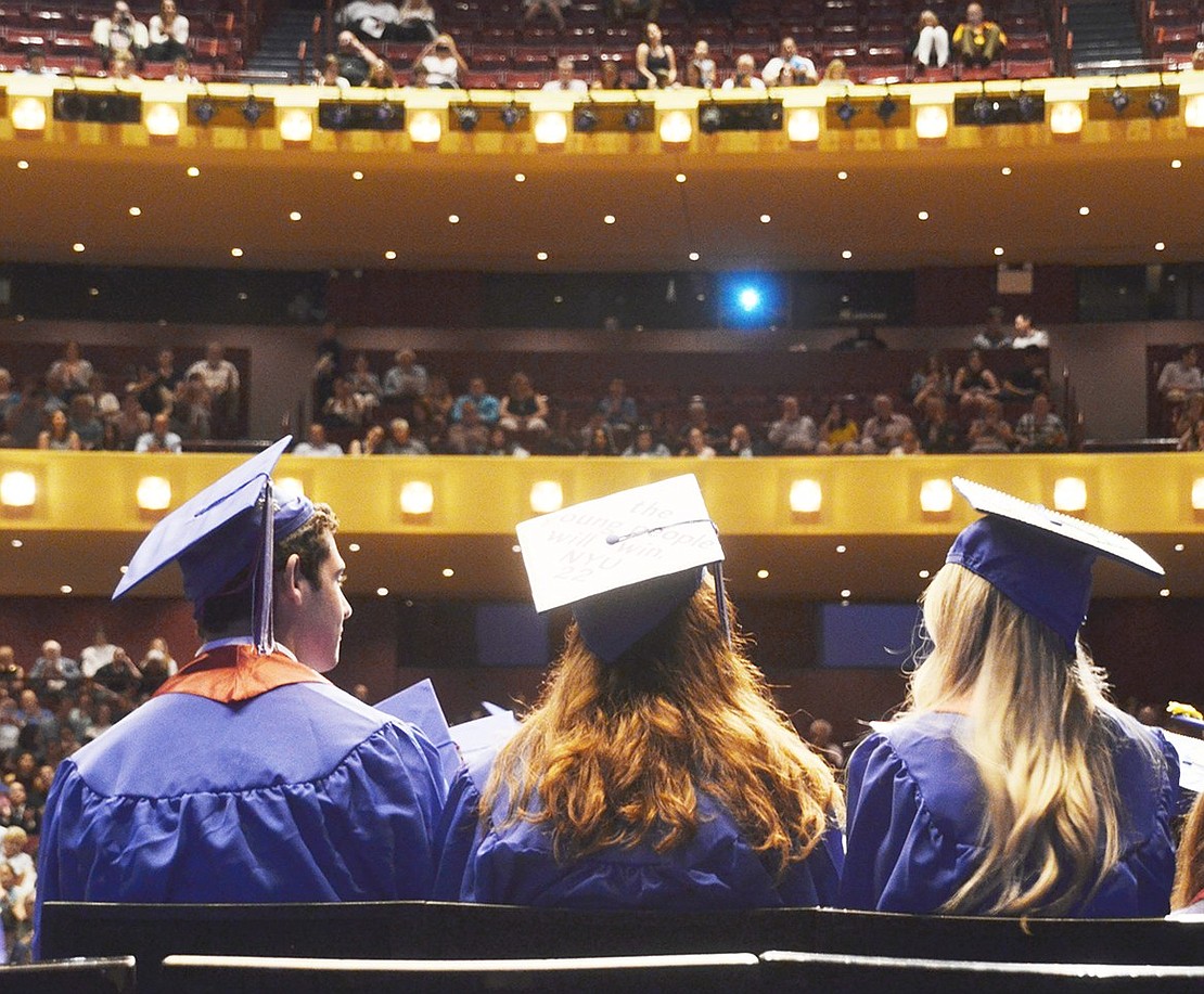 After four years of classes and studying, Matthew Frankel (left), Maya Finkman and Gabrielle Feuerstein wait for their names to be called in front of an auditorium packed three stories high. 