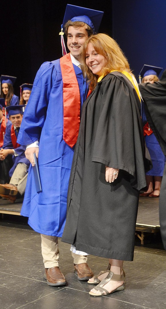 After personally giving Josh Schlactus his diploma, Board of Education member Jen Schlactus hugs her son. 