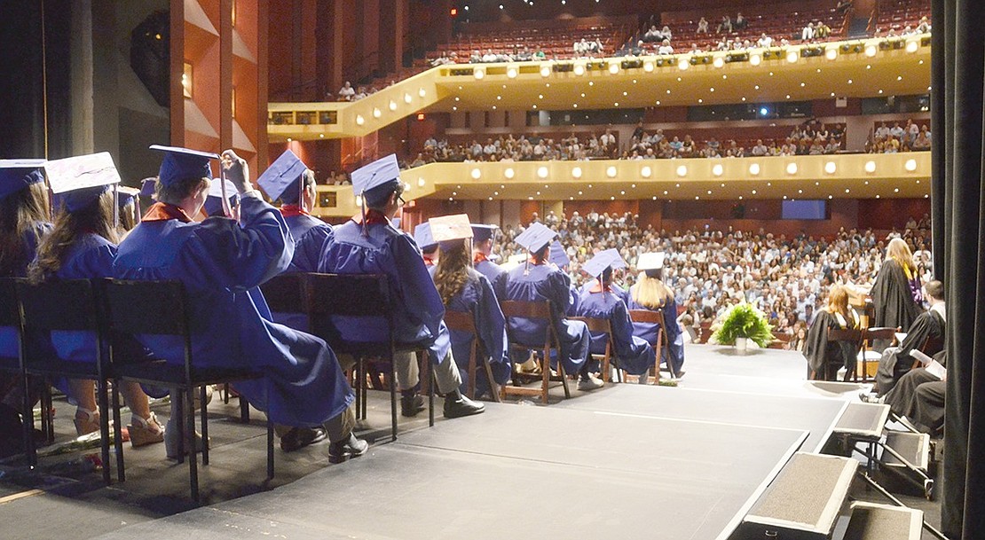 In front of an auditorium packed three stories high, the Blind Brook graduating seniors sit on stage to listen to speakers during the ceremony.