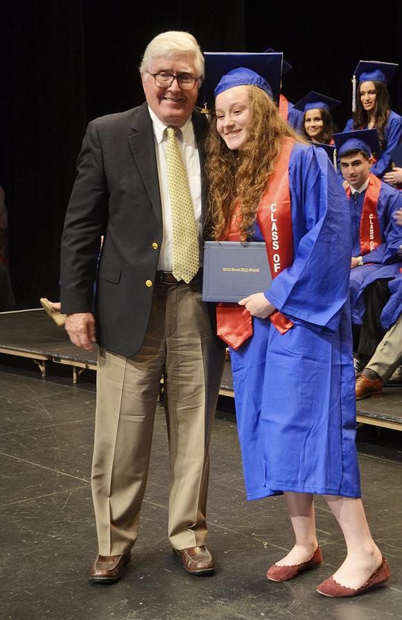 Former Board of Education member John Steinthal presents his granddaughter Hannah with her diploma. 