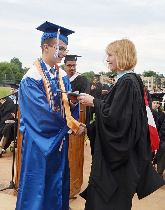 Class of 2018 valedictorian William Brakewood is the first to receive his diploma, which is specifically given by his mother and Board of Education member Carolee Brakewood.