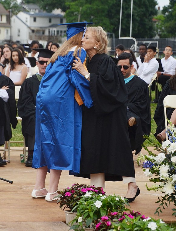 Board of Education Vice President Anne Capeci gives Melissa Stracuzzi a big hug after she specially delivers her diploma.