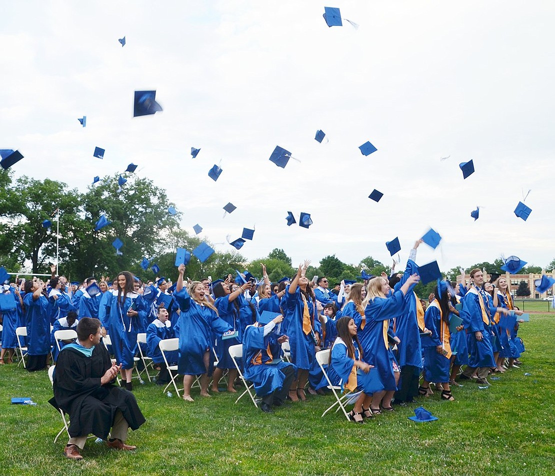 The class of 2018 gleefully cheers and simultaneously throws their caps into the air to celebrate officially becoming high school graduates.