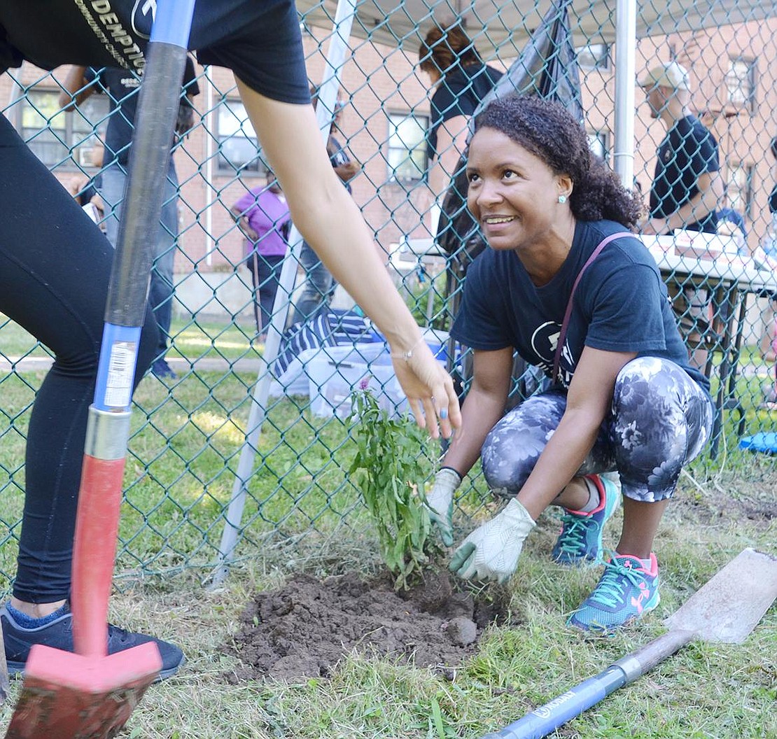 With a big smile on her face, Serve Day volunteer Jessica Davis, of Westchester Avenue, works to help maintain landscaping in the community garden at the Weber Drive public housing project on Sunday, July 8. Serve Day, sponsored by Redemption Community Church, invited volunteers and gardeners to come out and help clean up the Port Chester Community Gardens, located at Weber Drive, Terrace Avenue and Drew Street housing complexes owned and operated by the Port Chester Housing Authority. Redemption Community Church meets Sunday mornings in one of the AMC Loews movie theaters in Port Chester.