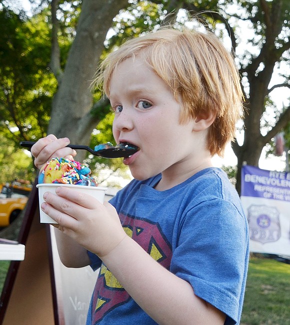 Terrace Court resident Connor Ware, 4, eats a spoonful of rainbow ice flavored ice cream topped with rainbow sprinkles at Ice Cream Friday on July 13 at Pine Ridge Park, sponsored by the Village of Rye Brook. Rye Brook Recreation will provide free ice cream, a bounce house and entertainment at the park for community members to enjoy every Friday throughout the month of July from 6 to 7:30 p.m.