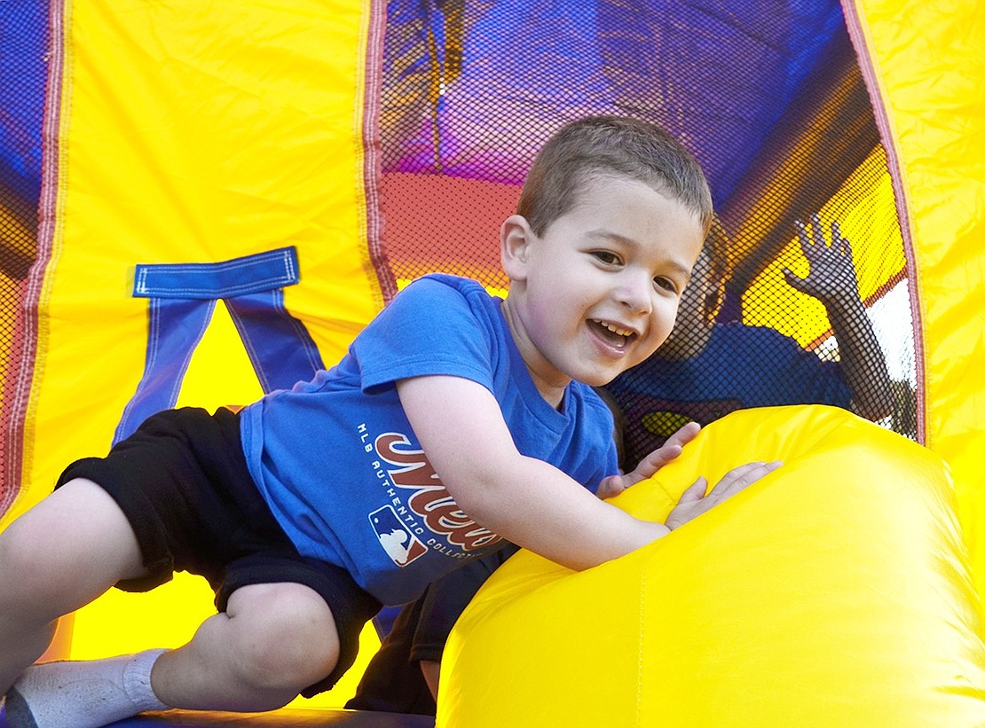 After having fun jumping around with friends, Brush Hollow Crescent resident Owen Kaplan, 3, slides out of the bounce house.