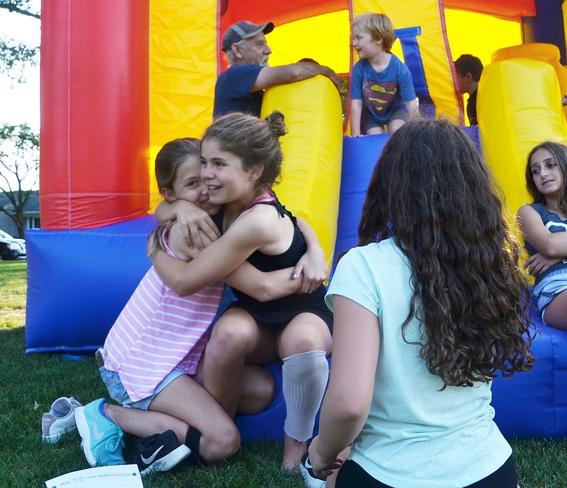 Surrounded by friends, and happy to see each other, Loch Lane resident Alex Maniscalco (right) and Knollwood Drive resident Anna Vnenchak embrace. 