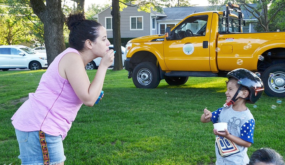 Alex Jakowsky, 4, giggles as his mother Isa blows bubbles in his direction.