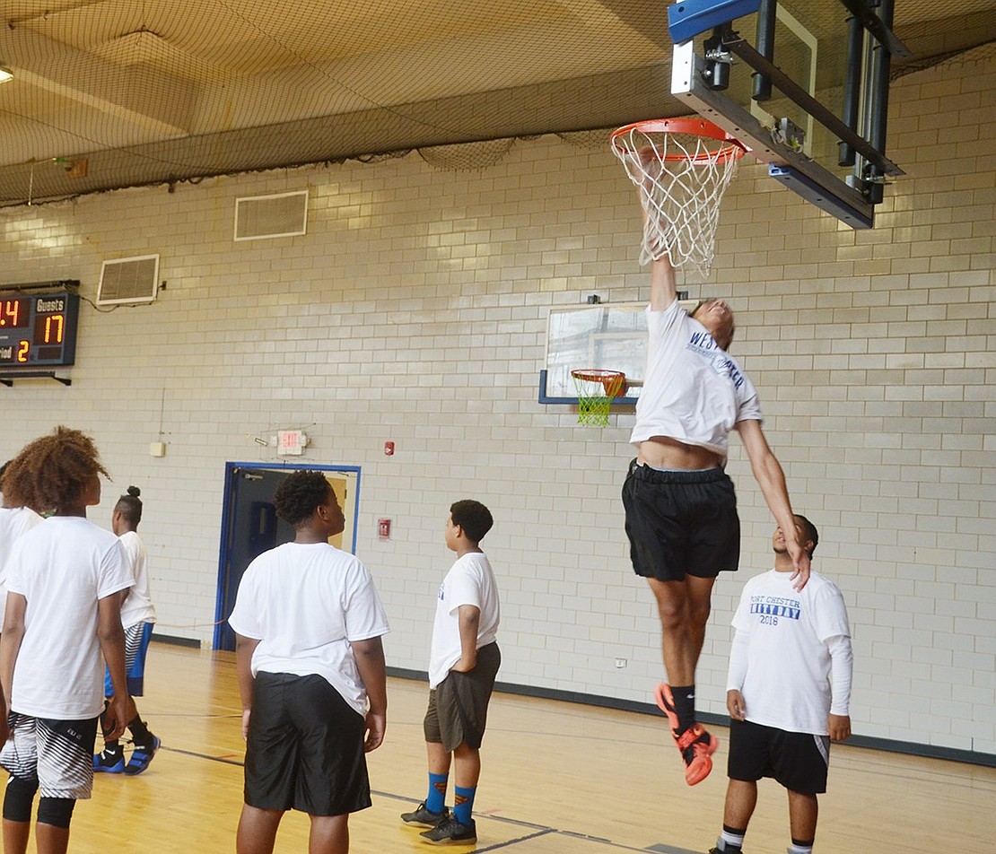 Port Chester High School rising sophomore Tony Roman practices his dunking skills during the Port Chester vs. Tarrytown basketball game at Unity Day on Saturday, Aug. 11. The festivities bringing together past and current P.C. residents was moved from Columbus Park to the Carver Center this year due to rain. 