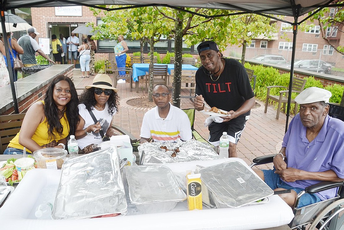 They came for a picnic and a picnic they shall have! Former and current Port Chester residents huddle under a tent to stay dry for lunch. From the left: Peggy Williams of New Rochelle, Grace Church Street resident Valerie Hammonds, Derrick Ricketts of Rye, Randy Owens of Atlanta, Ga., and Cleveland Fraiser of Mount Vernon.