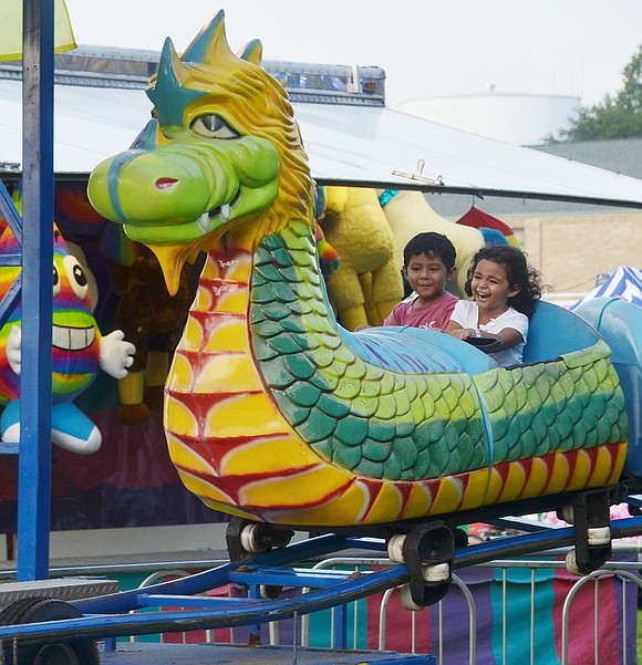 Port Chester resident Sophia Roque squeals with laughter on the dragon ride. The 4-year-old knows she’s safe since her 5-year-old big brother Christopher is right by her side at the St. John Bosco Carnival at Corpus Christi Field on Wednesday, Aug. 15. The joy will continue every day through Saturday, Aug. 18, starting at 6 p.m.