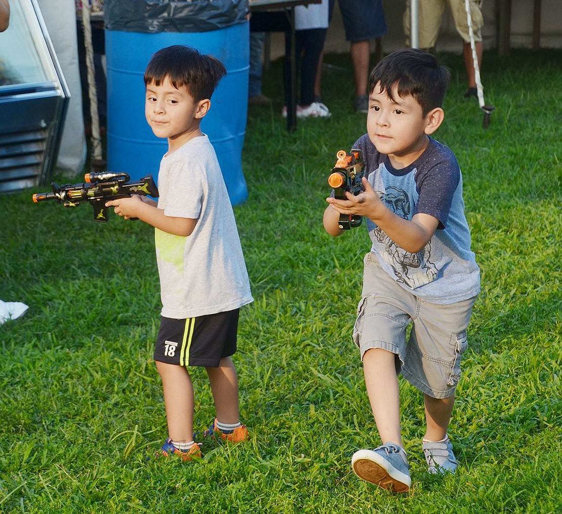 With brand new toy plastic guns, Bulkley Avenue brothers Ricardo (right), 4, and Enrique Hernandez, 3, are ready to catch some bad guys. 