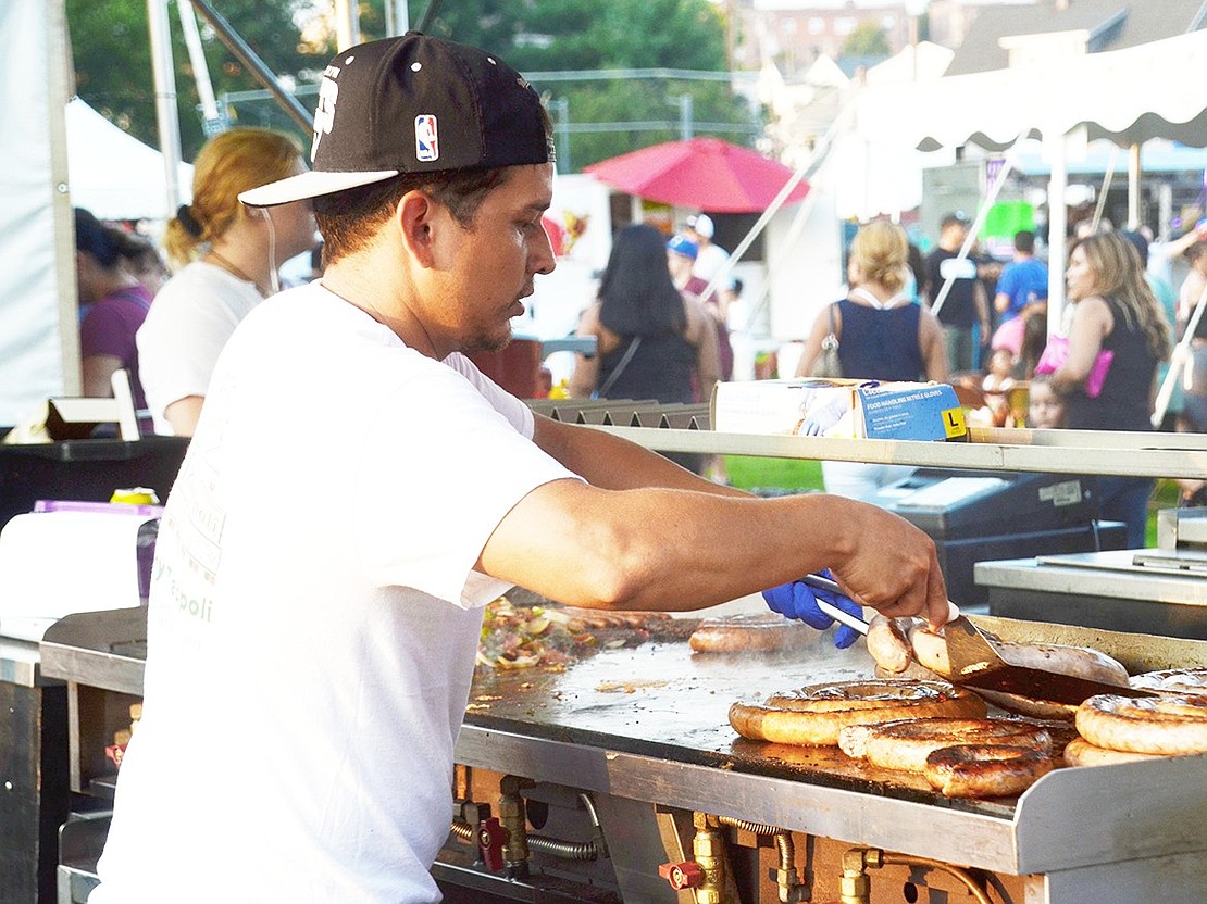 Johnny Zeppoli employee Herson Franco grills up some sausages and veggies for hungry patrons. 