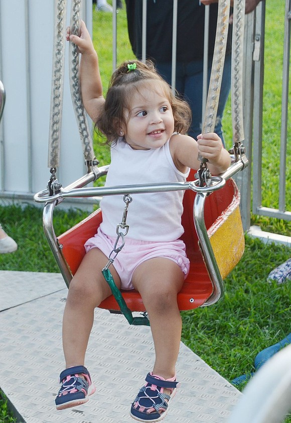 With smiles at mama, 21-month-year-old South Regent Street resident Marsi Jesurum tightly holds the ropes before the swings start moving. 