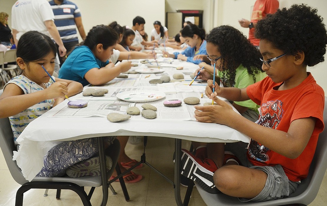 Edison Elementary School students Dario Estay, 8, and Bianca Garcia, 9, sit with more than 50 other kids eager to decorate several rocks with different colors and designs. 