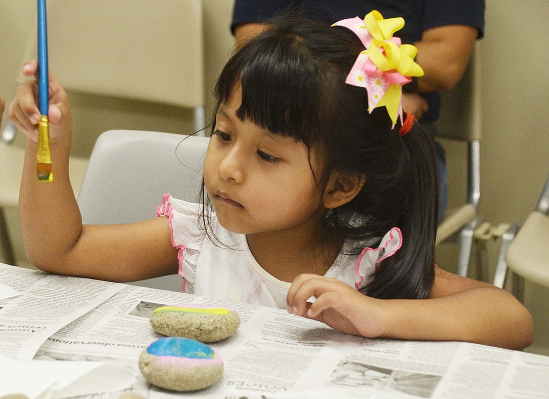 Smith Street resident Anna Rojas, 4, contemplates which color to smother her rock with next. 